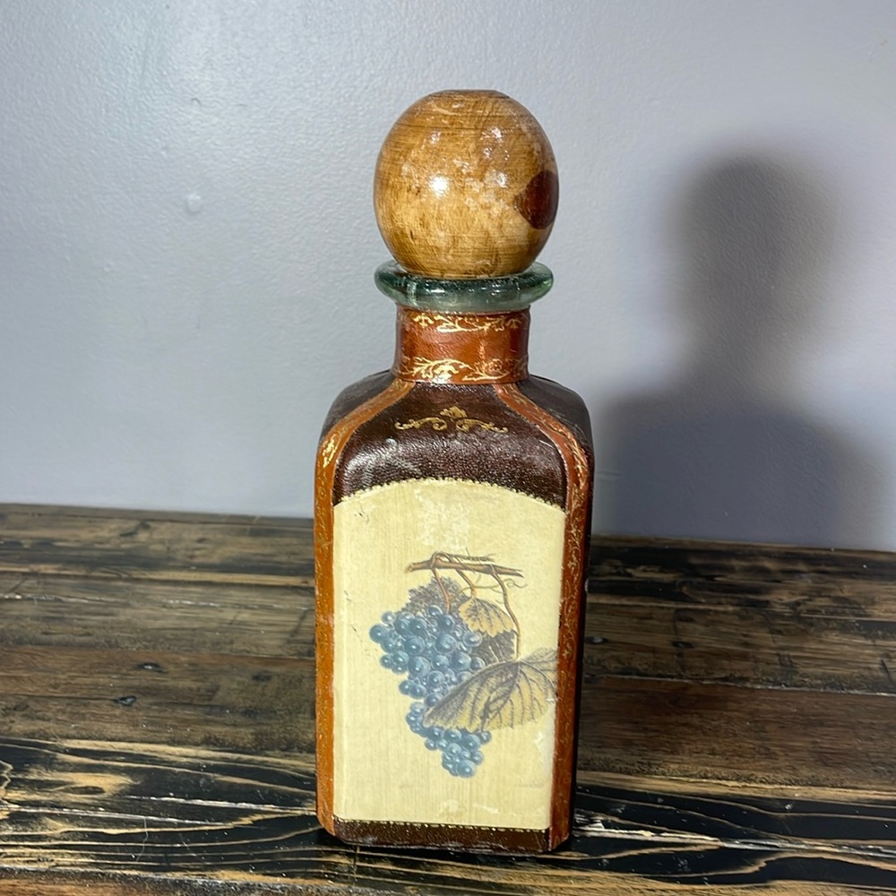 Made in Italy alcohol decanter leather wrapped.  Wooden top.